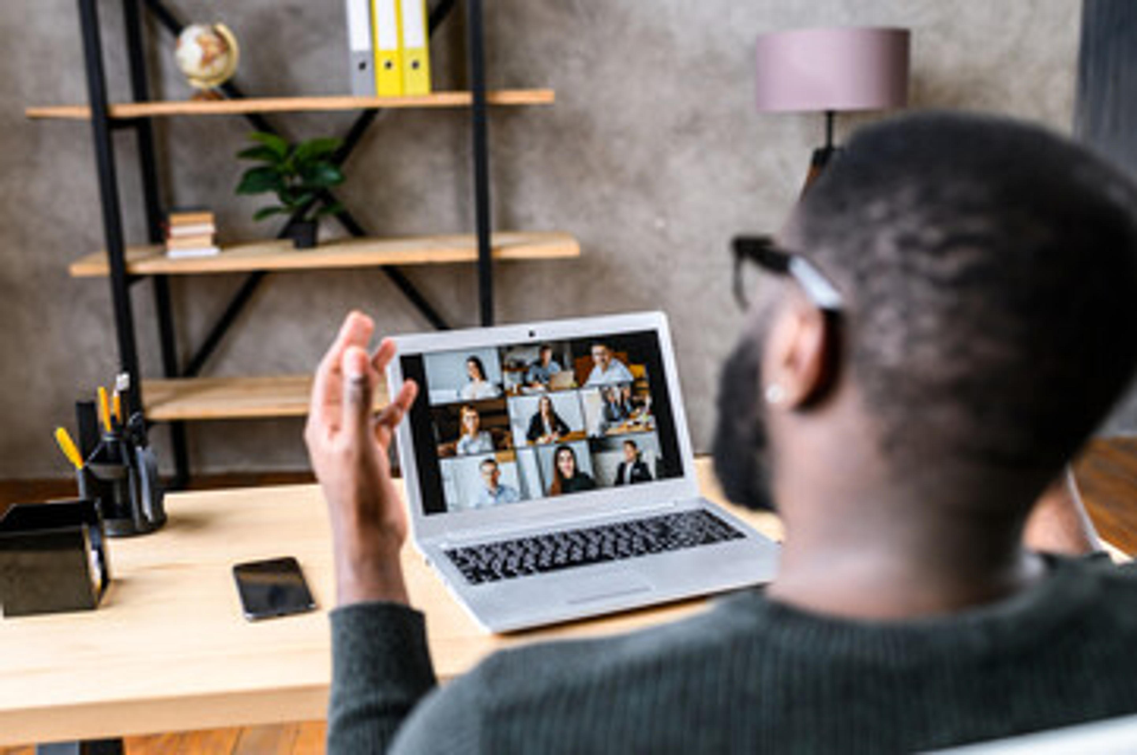 Confident African-American male worker talking online with coworkers, back view of black guy speaks and gestures to many people on video screen. Remote work, virtual meeting Stock Photo | Adobe Stock