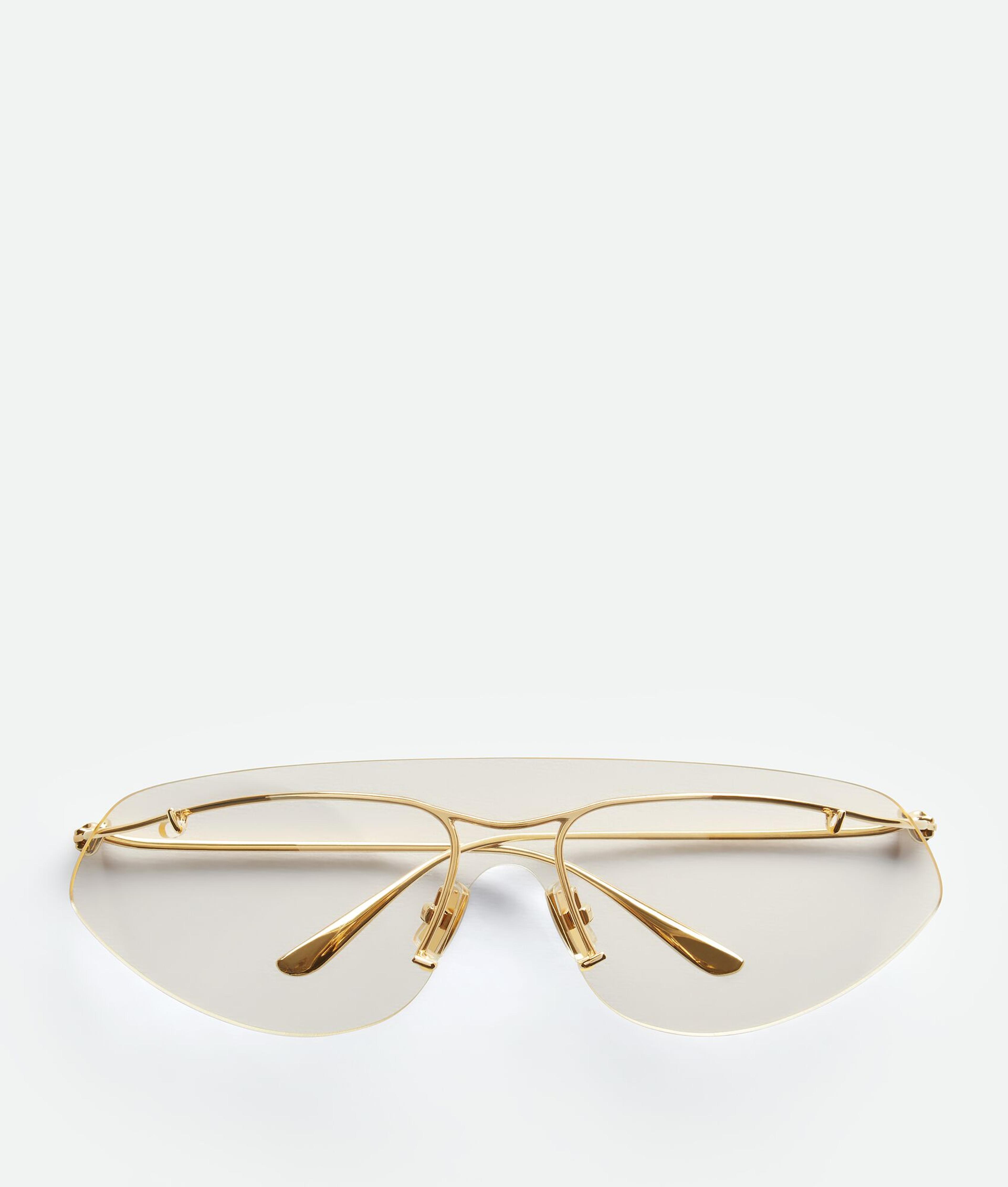 Bottega Veneta® Knot Shield Sunglasses in Gold/transparent. Shop online now.