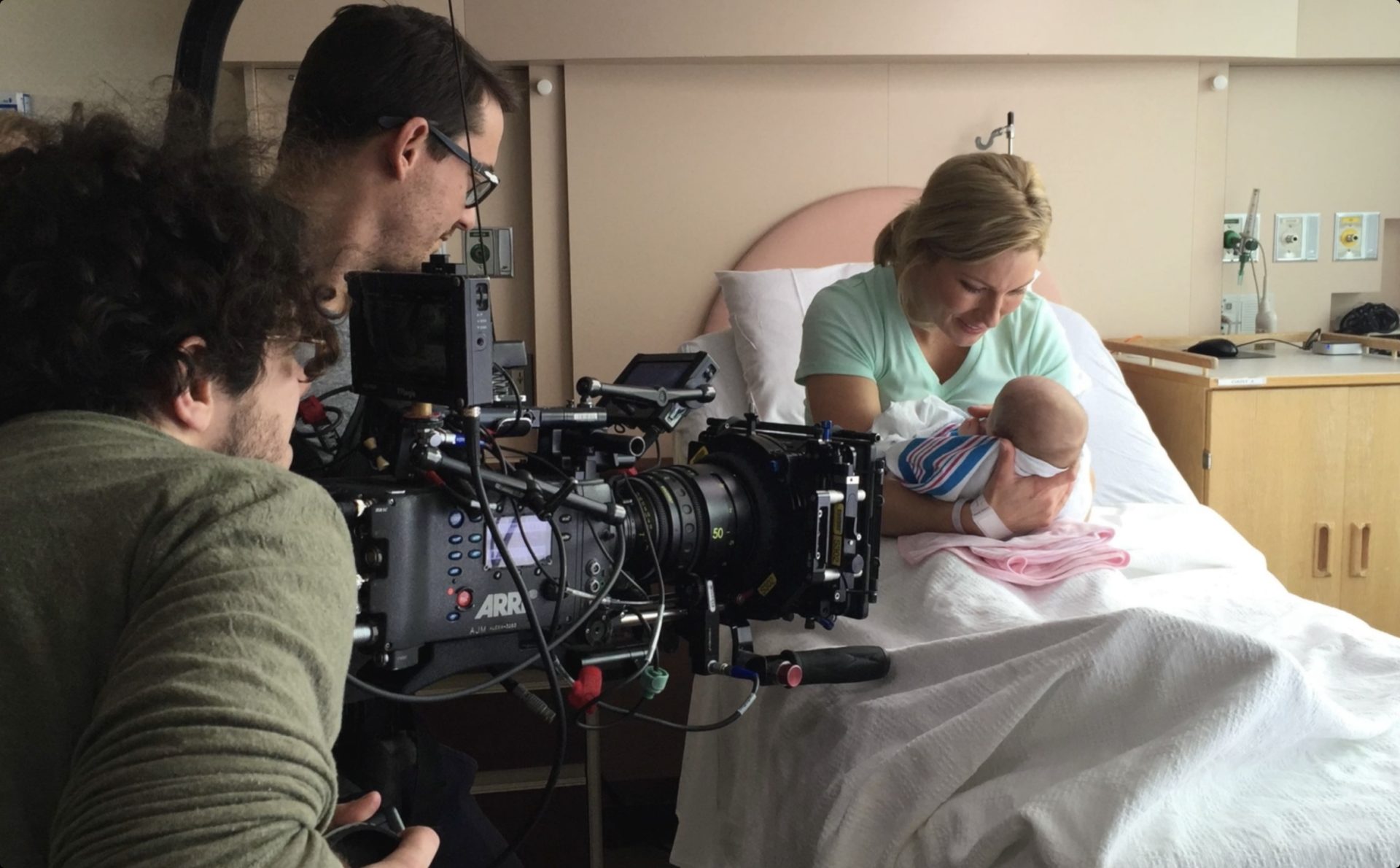 Film crew shooting a CK Health video of a new mother cradling her newborn in a hospital bed