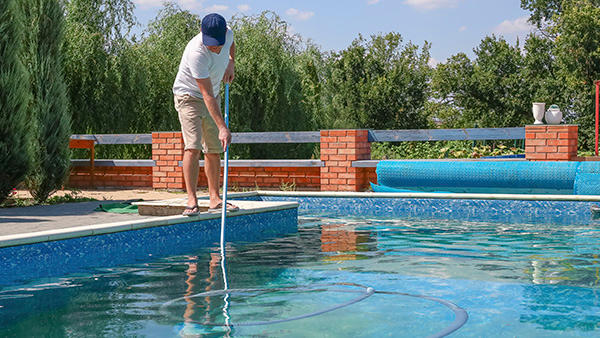 A man performing maintenance on a swimming pool