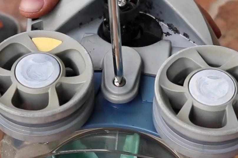 Screenshot 2026-04-15 101702 Am - Diy Pool Resources - Inyopools.com Close-up of a technician tightening a bolt between two gray circular propeller-like components on a blue device.