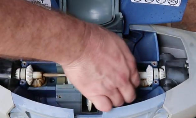 Screenshot 2026-04-15 112642 Am - Diy Pool Resources - Inyopools.com Close-up of a technician's hand adjusting white gears inside a blue motor housing.