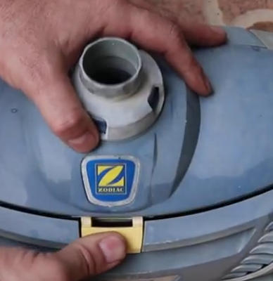 Hands removing the cap from a blue Zodiac-brand fuel tank.