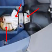 Under-hood view of a car engine bay with three red arrows highlighting a white electrical connector, a fuse/relay block, and a metal bracket.