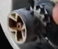 Close-up of a round, black four-pin electrical connector with a white outer shell.