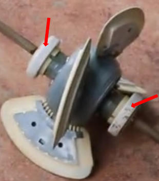 Close-up of a rotary tool attachment with an abrasive wheel, guards, and a clamp, used for grinding and polishing surfaces.