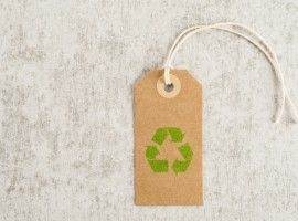 Recycling symbol on brown paper tag. Concept of environmental awareness, eco lifestyle and green eco-friendly shipping.