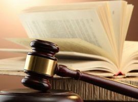 wooden gavel and books on wooden table,on brown background