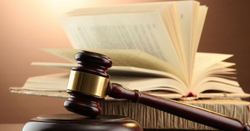 wooden gavel and books on wooden table,on brown background