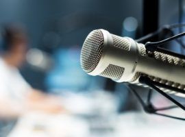 young man dj works in modern broadcast studio