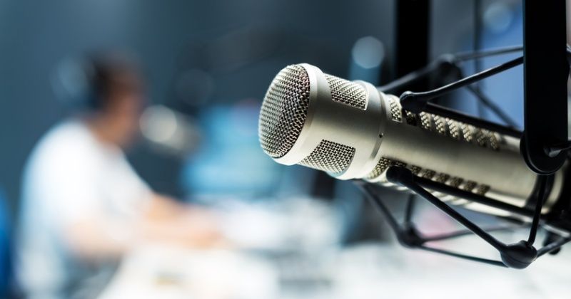 young man dj works in modern broadcast studio