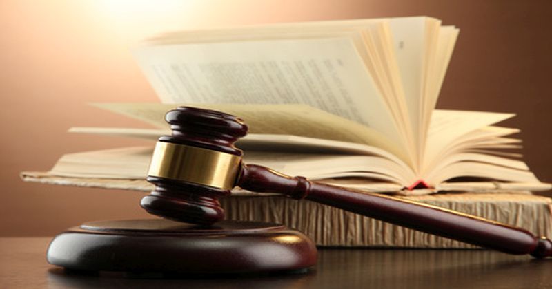 wooden gavel and books on wooden table,on brown background