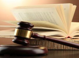 wooden gavel and books on wooden table,on brown background