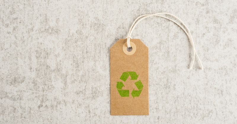 Recycling symbol on brown paper tag. Concept of environmental awareness, eco lifestyle and green eco-friendly shipping.
