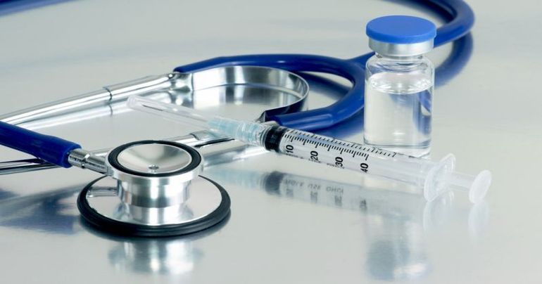 Syringe, vial and stethoscope on surgical tray.