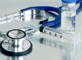 Syringe, vial and stethoscope on surgical tray.
