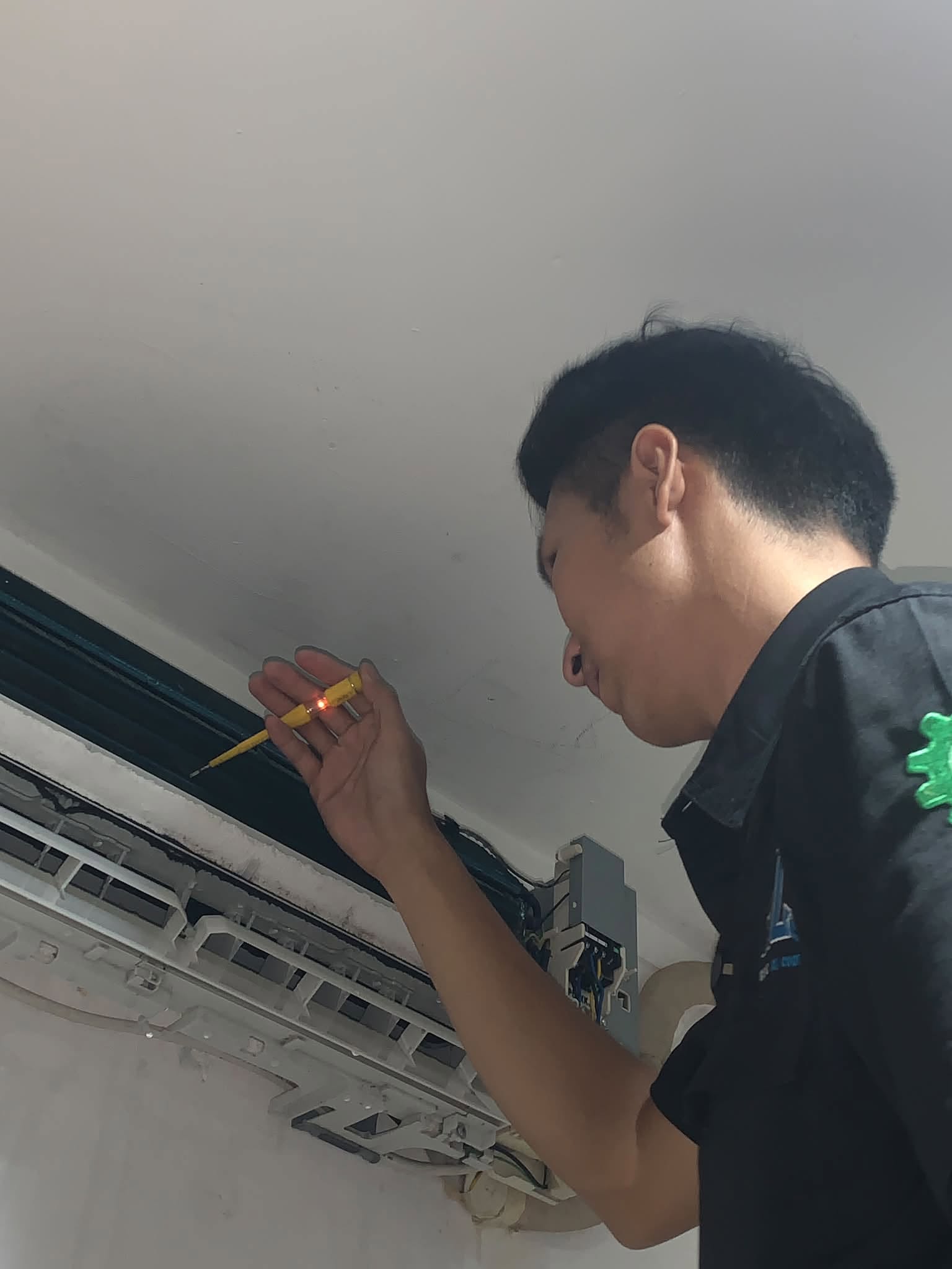 Teknisi BOS AC sedang memperbaiki AC di Palembang