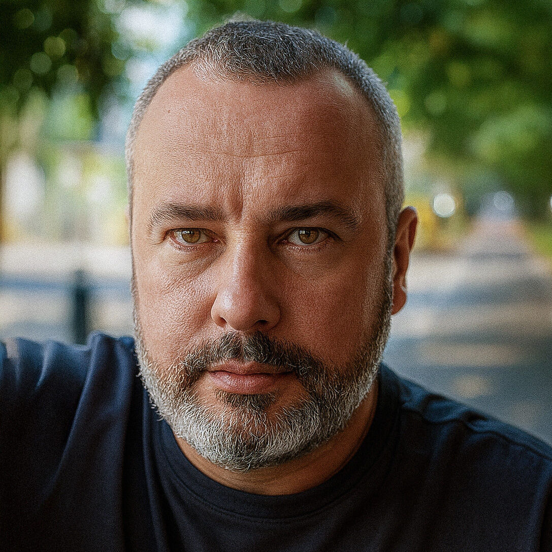 A close up profile picture of Silviu Jureschi, with a blurred background of streets and trees.