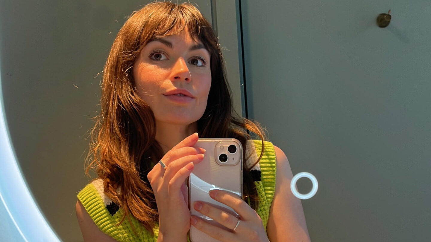 Imogen Comrie taking a picture of her reflection in a mirror.