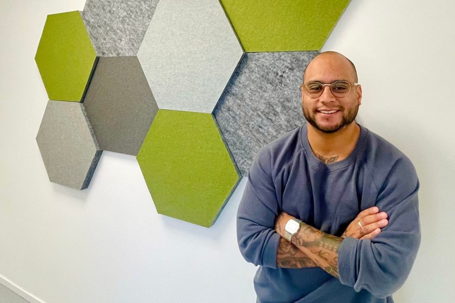 Eddie Sjöberg leans against the wall at his office, decorated with green soundproof pentagonal tiles.