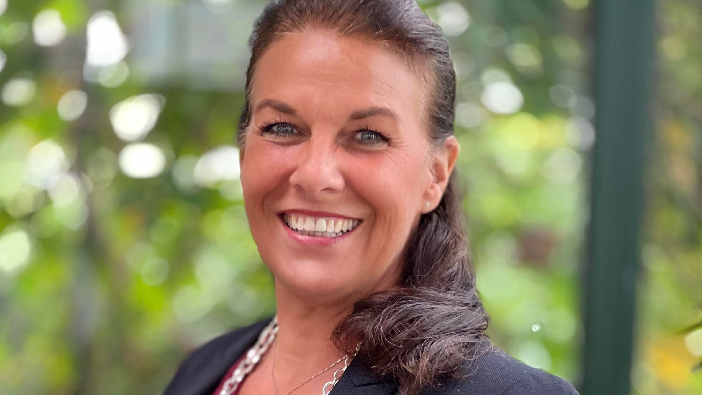 Yvonne Boe wearing a suit and smiling at the camera.