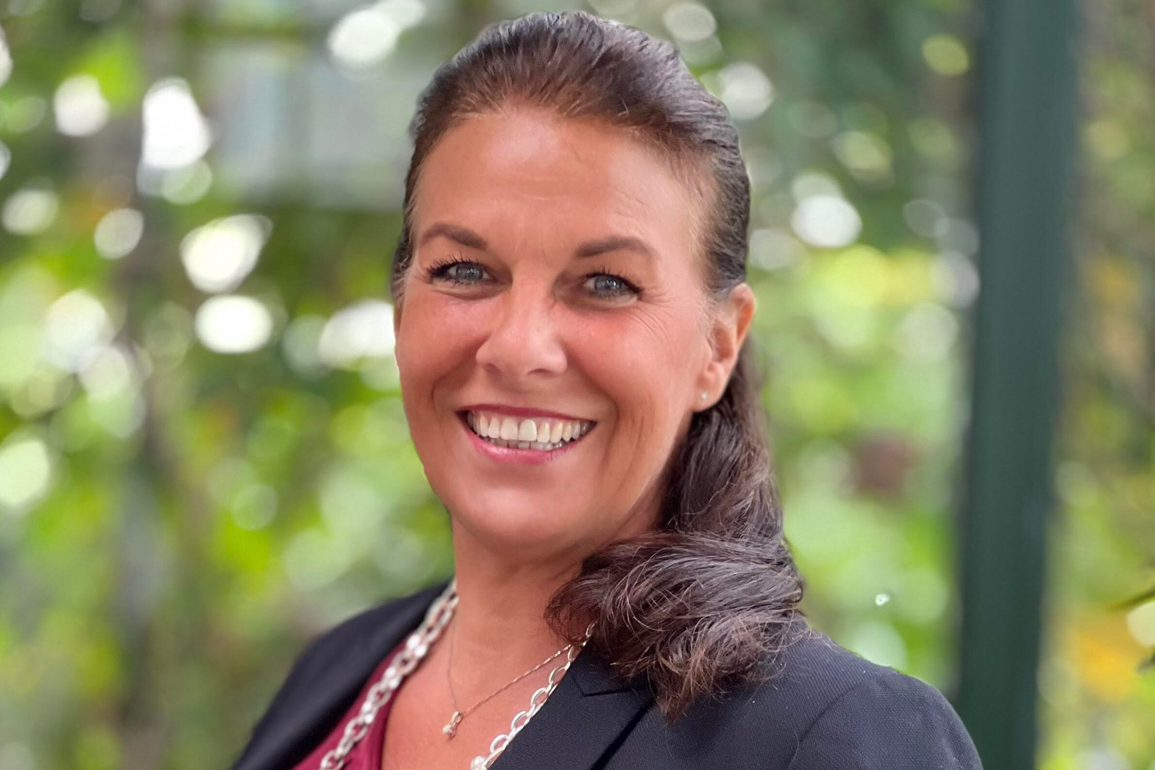 Yvonne Boe wearing a suit and smiling at the camera.