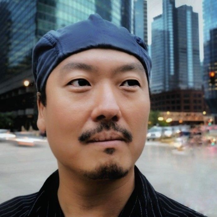 A portrait of Young Jin Jim wearing a blue cap, staring into the distance.