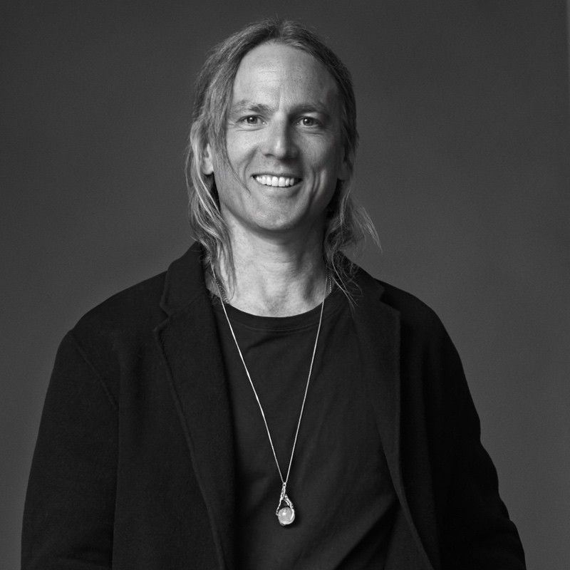 A grayscale portrait picture of Adam Springfeldt, smiling at the camera.
