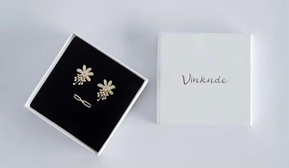 White minimalist packaging with earrings and ring