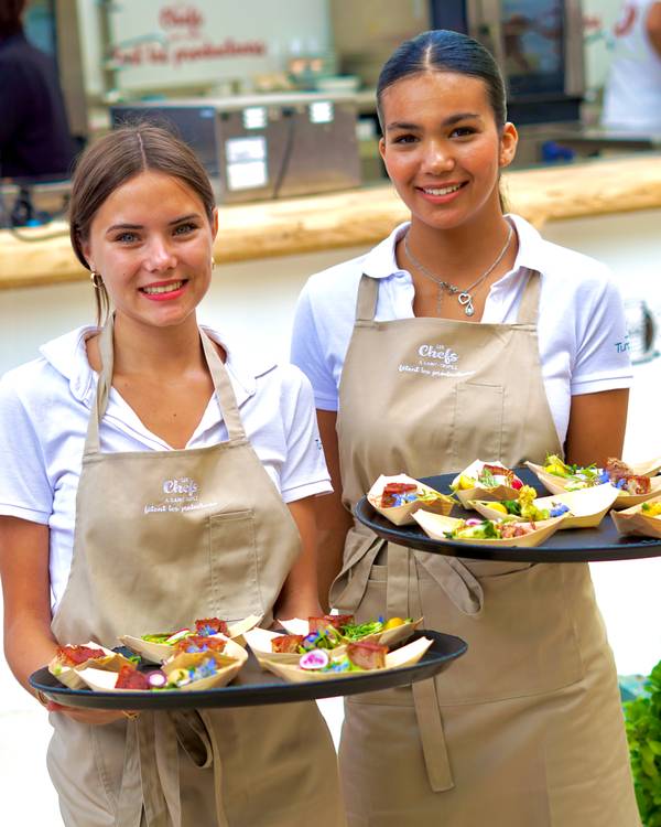 Hôtesses souriantes portant des plateaux de victuailles