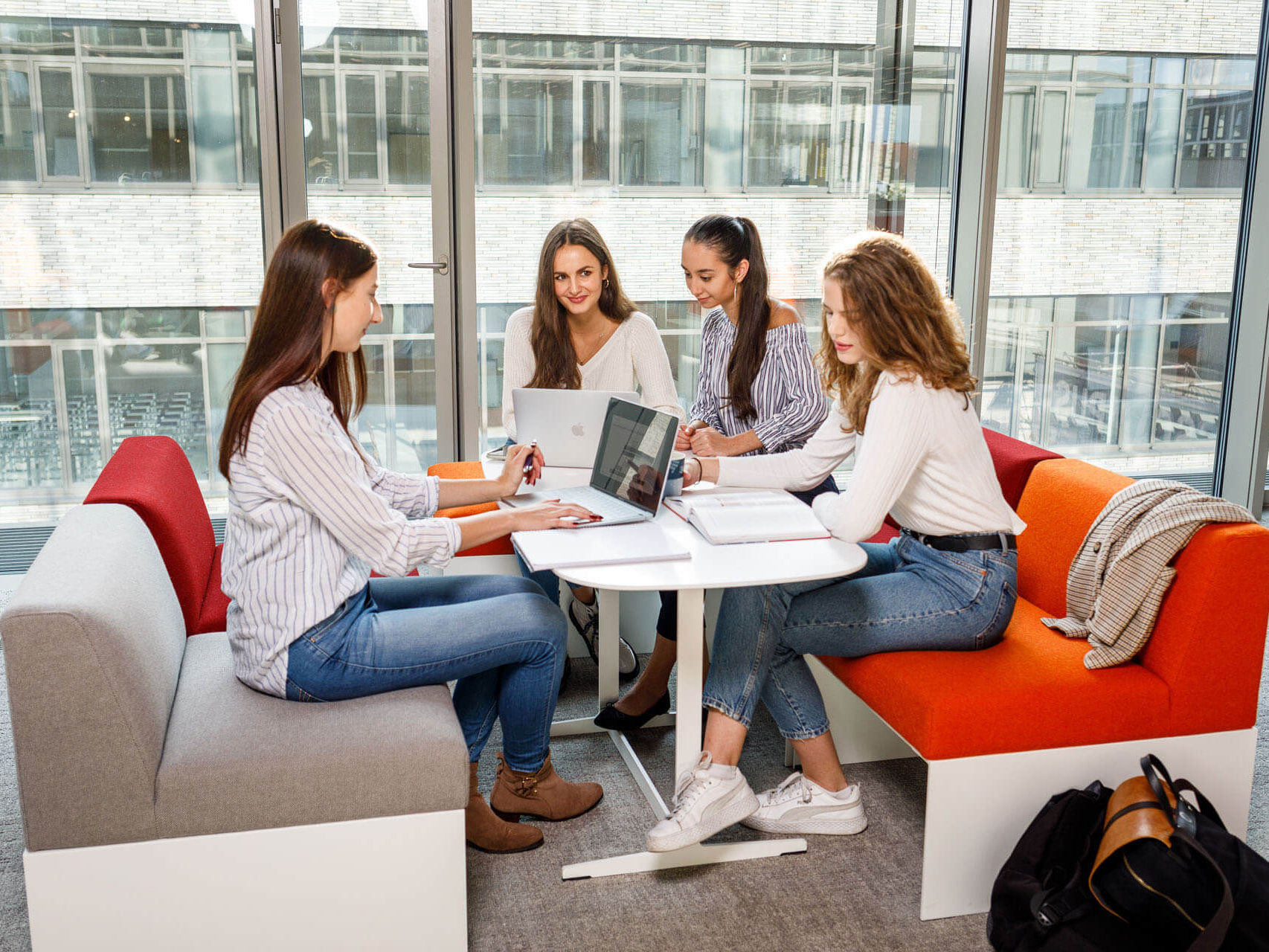 Sechs Studenten sitzen und lächeln