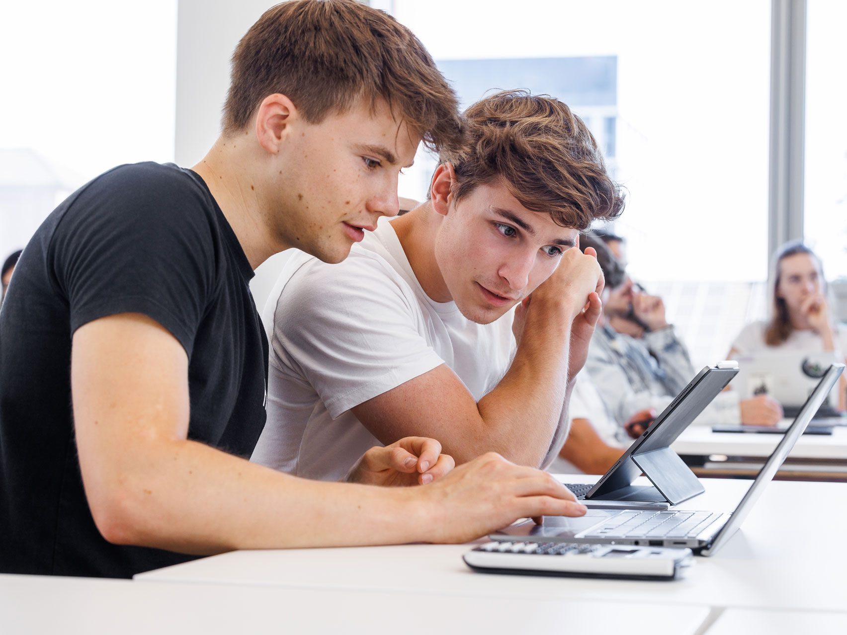 Zwei Studenten schauen in einen Laptop