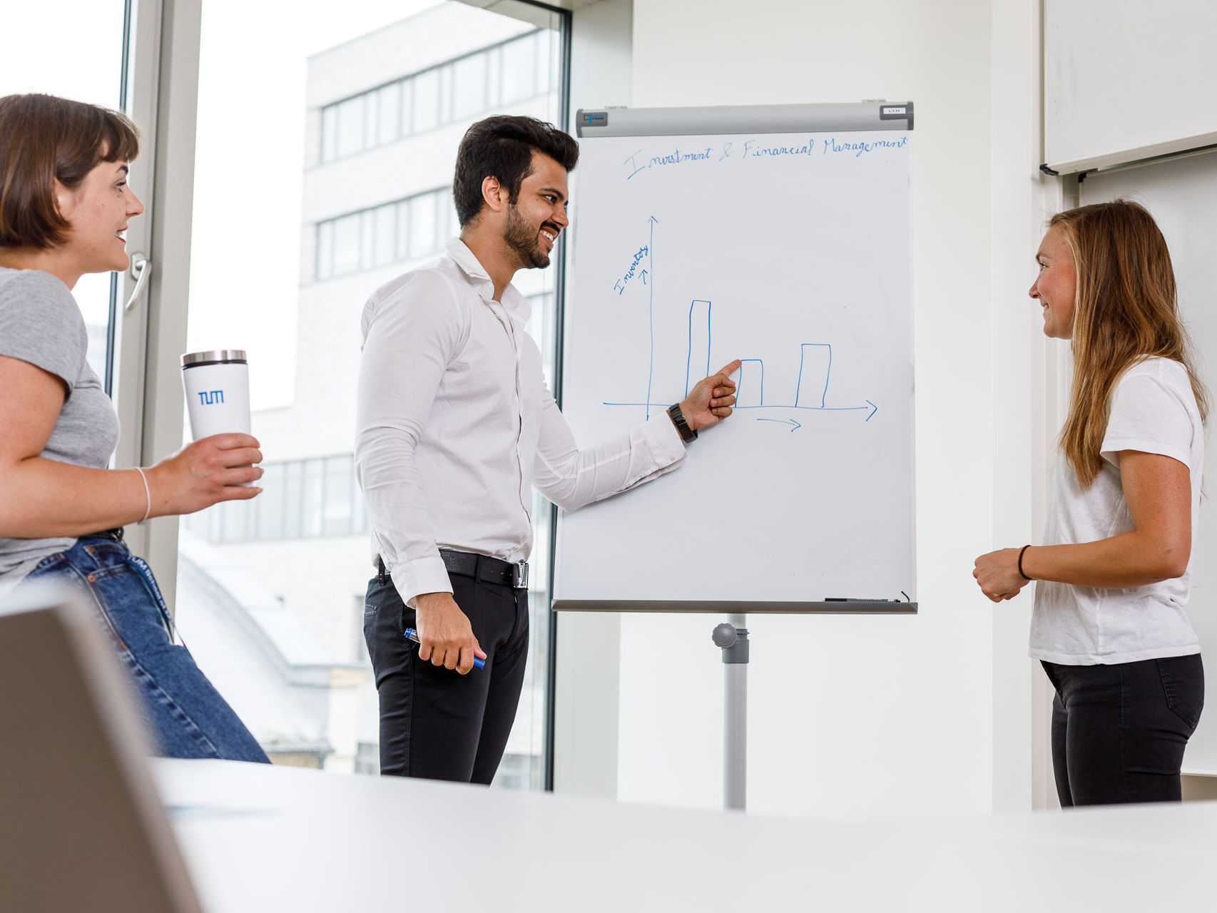 Drei Studenten arbeiten an einem Flipchart