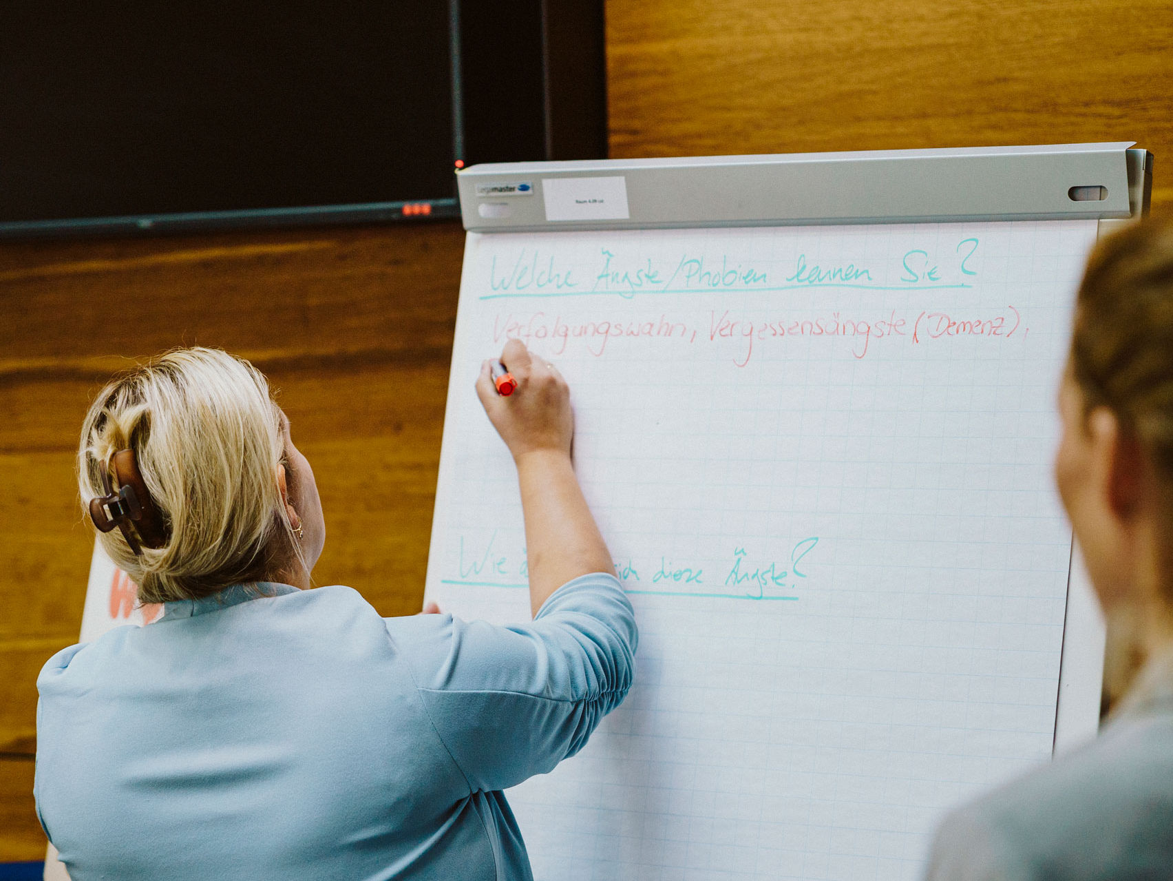 Frau schreibt auf Flipchart