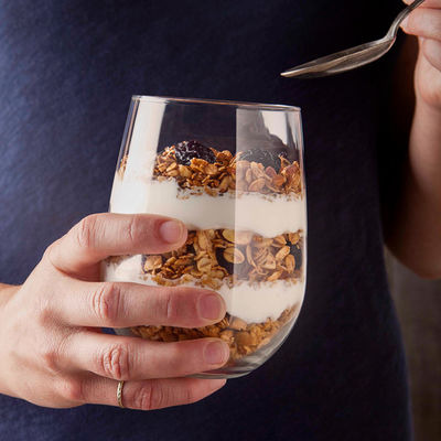 Granola and yogurt parfait in stemless wine glass