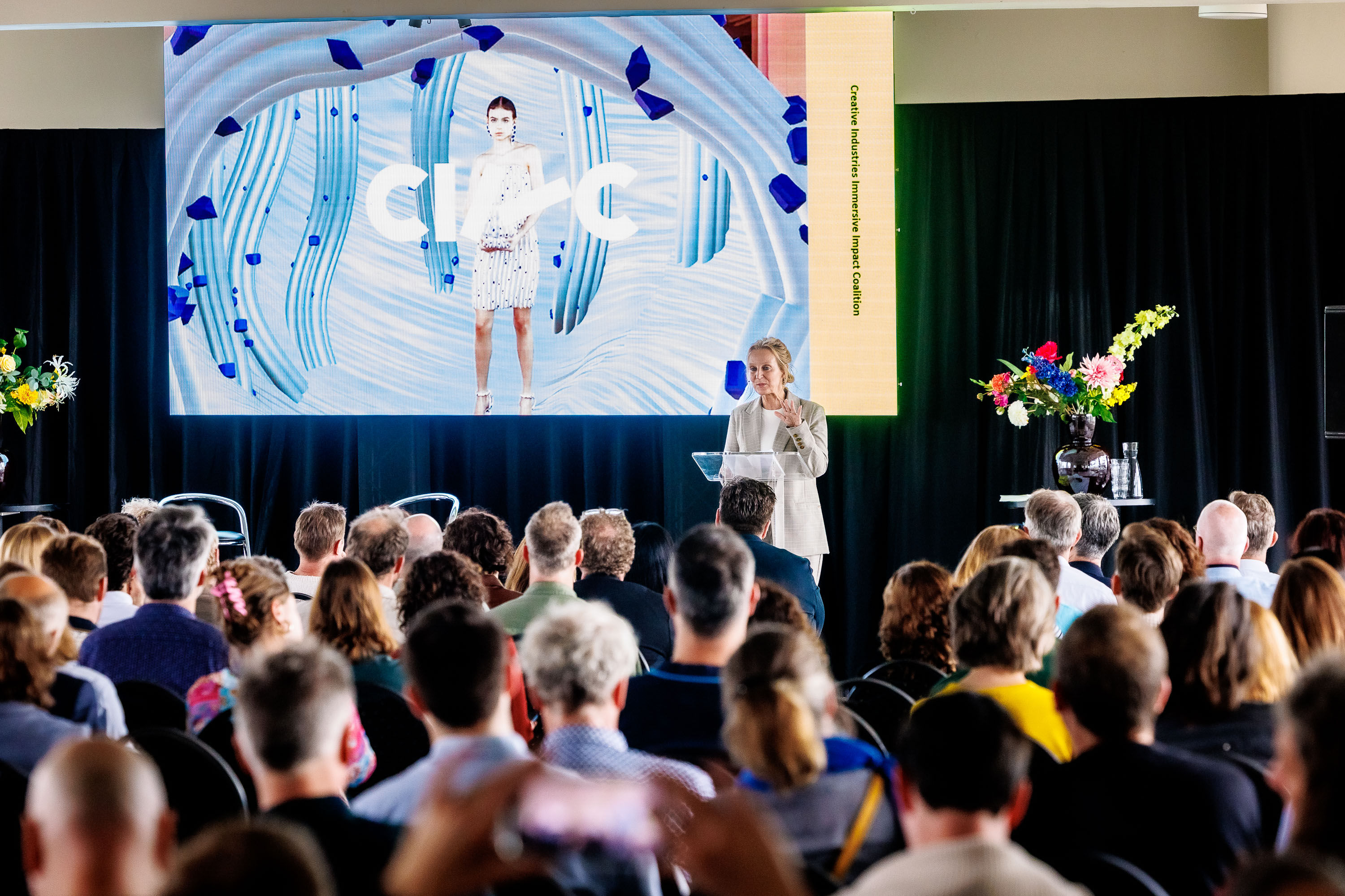Spreker op het podium voor een groot CIIIC-scherm tijdens het Jaarevent