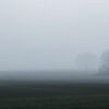 Thick November fog blankets the landscape, obscuring wind turbines and solar fields. A stark reminder of the challenges faced during the dark doldrums, where renewable energy production slows to a crawl.