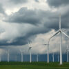Wind turbines rise against a stormy sky, symbolising the beauty and challenges of Germany's Energiewende—an ambitious pursuit of renewable energy amidst uncertainty