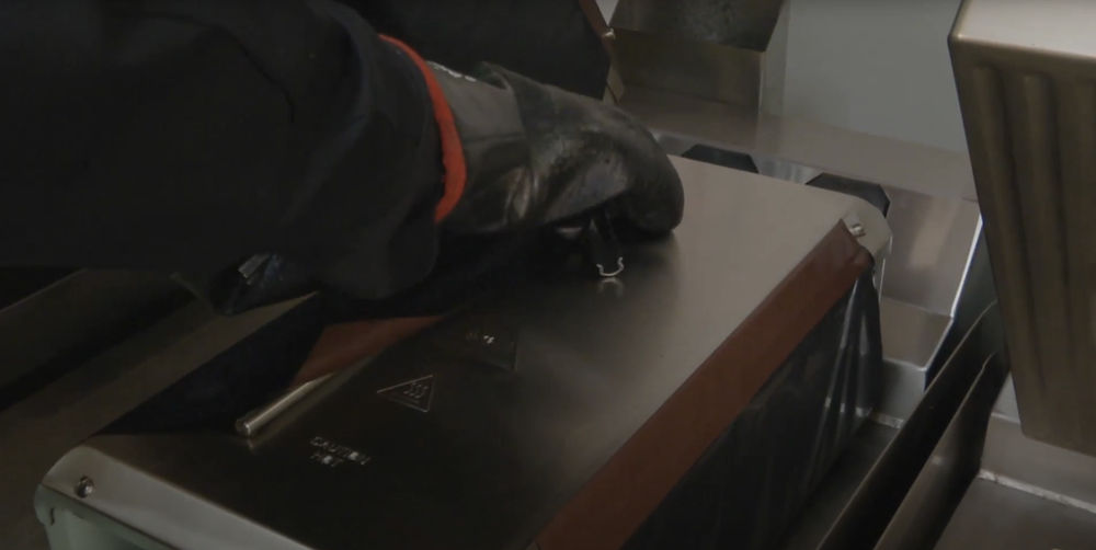 Technician removing top clip to take off Teflon release sheet from the upper platen.