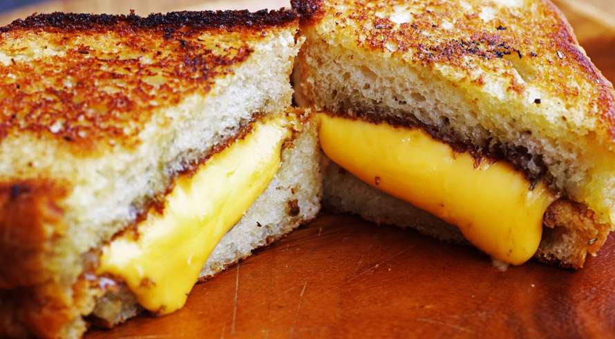 weed Grilled cheese sandwich on wood platter with rosemary bread &amp; melted cheddar cheese