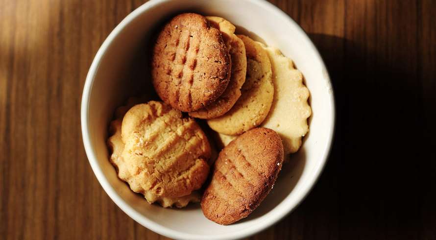 a bowl on a wooden surface with cannabis infused sugar cookies in it