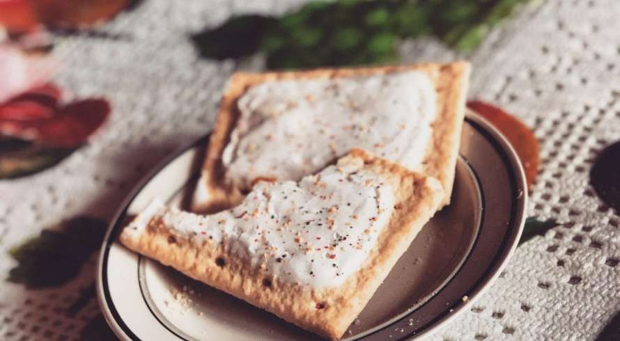 Two cannabis infused pop tarts on a plate which is on a tablecloth with berries