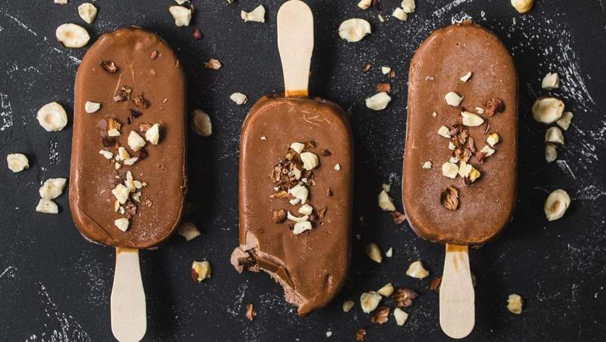 3 weed nuttela ice pops on a black table with nuts spread on top of them artistically