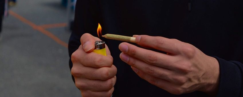 person lighting a joint at 4/20 rally. Sunset Beach Park, Vancouver, Canada
