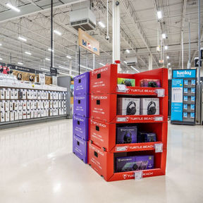 Retail electronics aisle lit by bright overhead LED fixtures