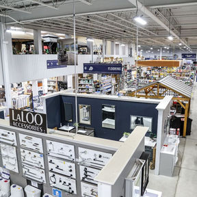 Home improvement store interior with flooring and accessory displays lit by overhead LED fixtures