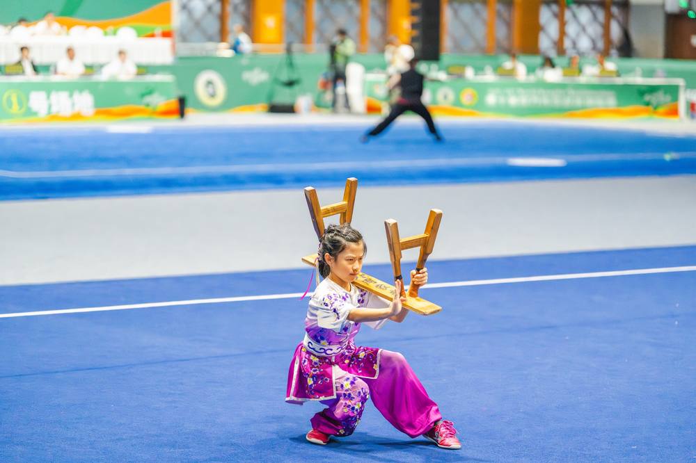 Young Wushu student holding a broadsword in a strong stance
