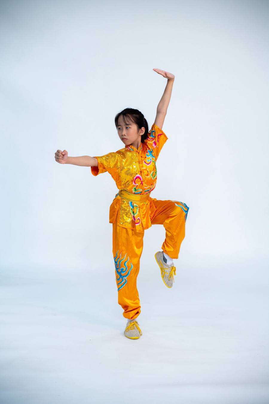 Young Huacheng Elite student in a gold uniform mid-form