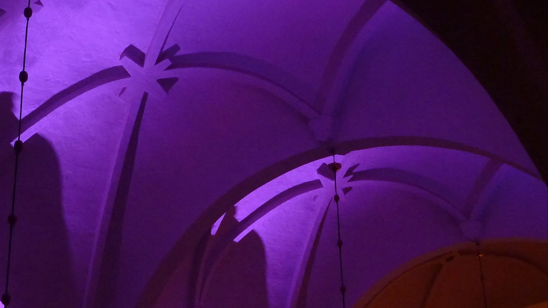 bild på valv i sankt Olovs kyrka i Skellefteå. Valven är belysta med violett och grönt ljus. 