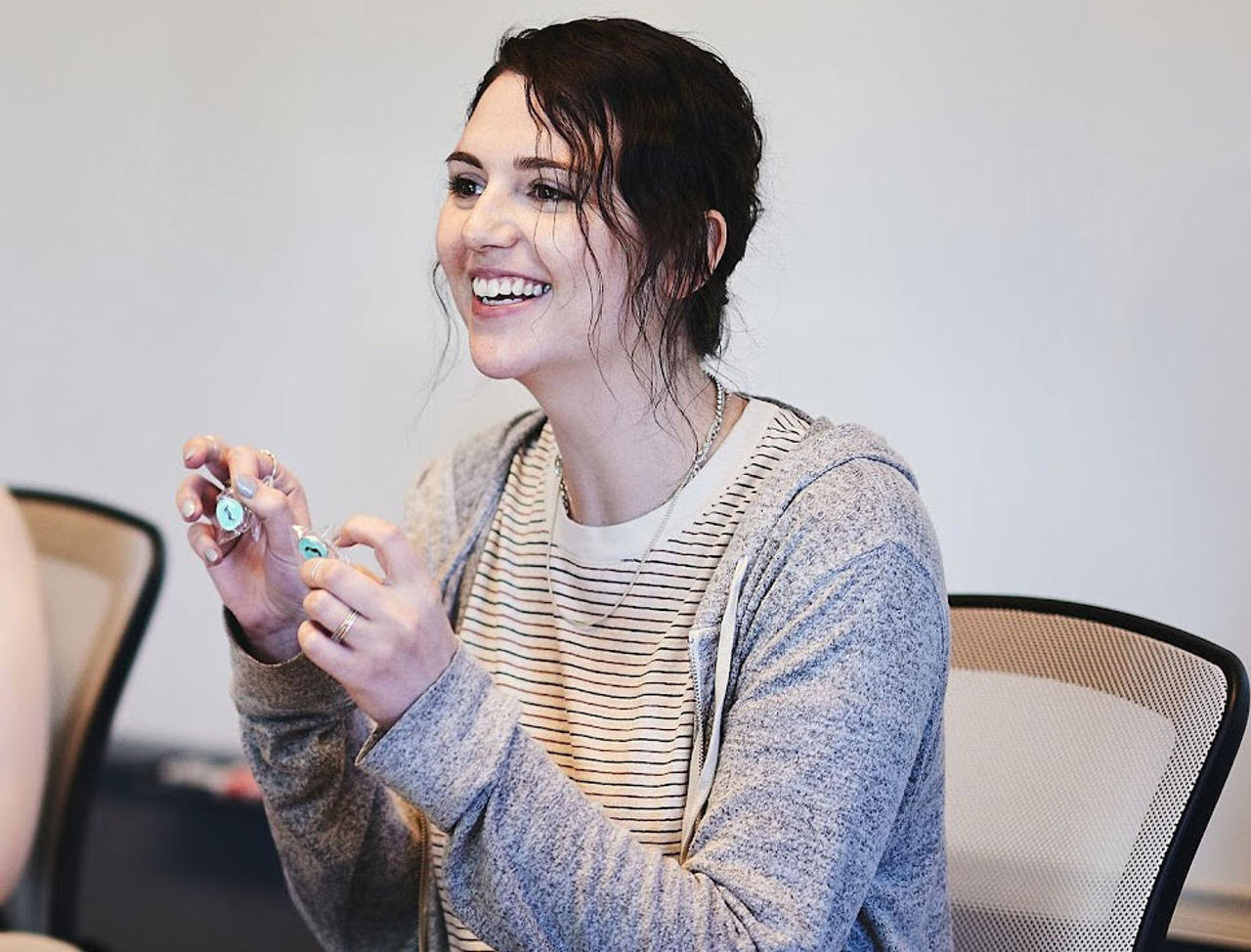 A candid moment at Cuttlesoft headquarters captures a software engineer sharing insights during a team discussion, embodying the company's core value of 'Learn to Fish.' Her engaged expression and animated gesture demonstrate how Cuttlesoft combines technical expertise with clear communication when developing solutions across healthcare, fintech, and enterprise sectors. This natural interaction reflects the company's philosophy that 'humanity is our code,' showing how they make complex technical concepts accessible while delivering custom software solutions in Python, React, and Ruby. The casual yet professional environment showcases Cuttlesoft's approach to creating a workplace where innovation and empathy coexist, supporting their mission of building both powerful software and lasting client relationships.